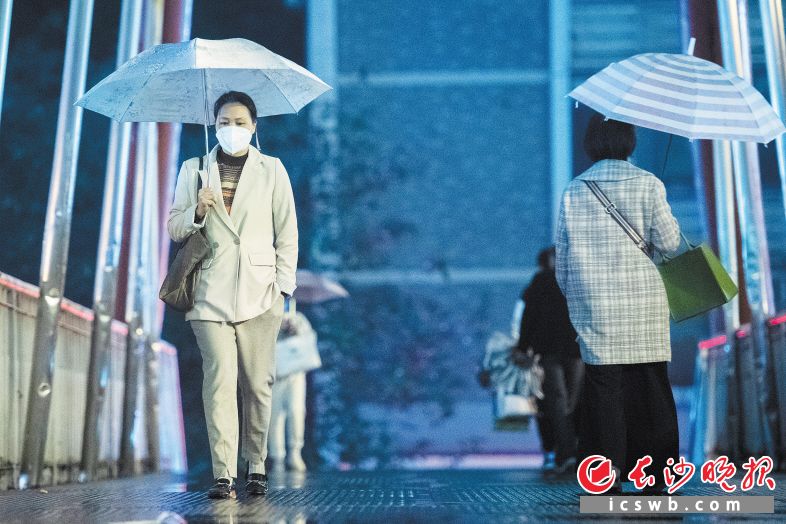 市民撑伞从东二环荷花园人行天桥走过。 长沙晚报全媒体记者 黄启晴 摄